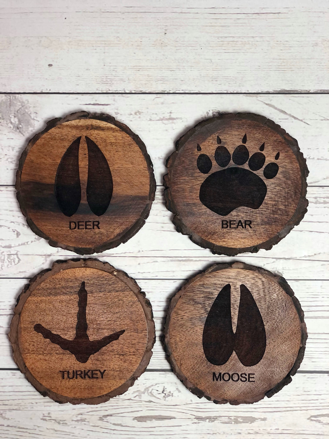 set of 4 round wildlife tracks-themed Acacia wood coasters.